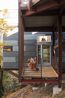 A porch at the bottom floor level serves as a rest space, play area, and work spot when Hale pulls out his tools. The horizontal window above connects the first floor to the deck so Hale and Edmonds can keep a watchful eye on the girls when they play outside.