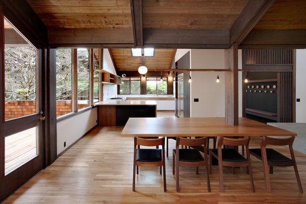 The light fixtures, a string of dangling lights seen above the dining table, emulate what SHED Architects principal Thomas Schaer calls Zema’s “builderly” style: straightforward and unpretentious. The wooden screens, seen top right, are all-new to the house but follow Zema’s Japanese-inspired style. Photo 4 of Zema Redux modern home