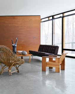 Architect William Massie built a hybrid prefab home for vintage retailer Greg Wooten, who handled the interiors. In the living room is a 1950s Franco Albini rattan chair, a Crate chair designed by Gerrit Rietveld in 1934, and a 1970s sofa by Edward Axel Roffman. The tall ceramic piece is by Bruno Gambone.