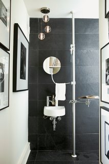 Going Vertical<br><br>In the guest bathroom, a mirror, soap dish, hand towels, and a tray hang from a modular floor-mounted Autopole shelf system by Alu. The hardware adds an industrial note to the look of the room and takes up less area than a cabinet. The wall and floor are clad in a stone called Indian granite.<br><br>alu.com