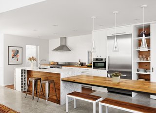 10 Modern Examples That Show How to Use Marble in the Kitchen - Photo 1 of 11 - Alter integrated wood from the original bungalow into the kitchen and covered the island in Carrara marble. New appliances include a Wolf range, a Broan hood, and a Miele oven and refrigerator. The Fucsia pendant lights are by Achille Castiglioni for Flos, and the benches are from RAD Furniture.