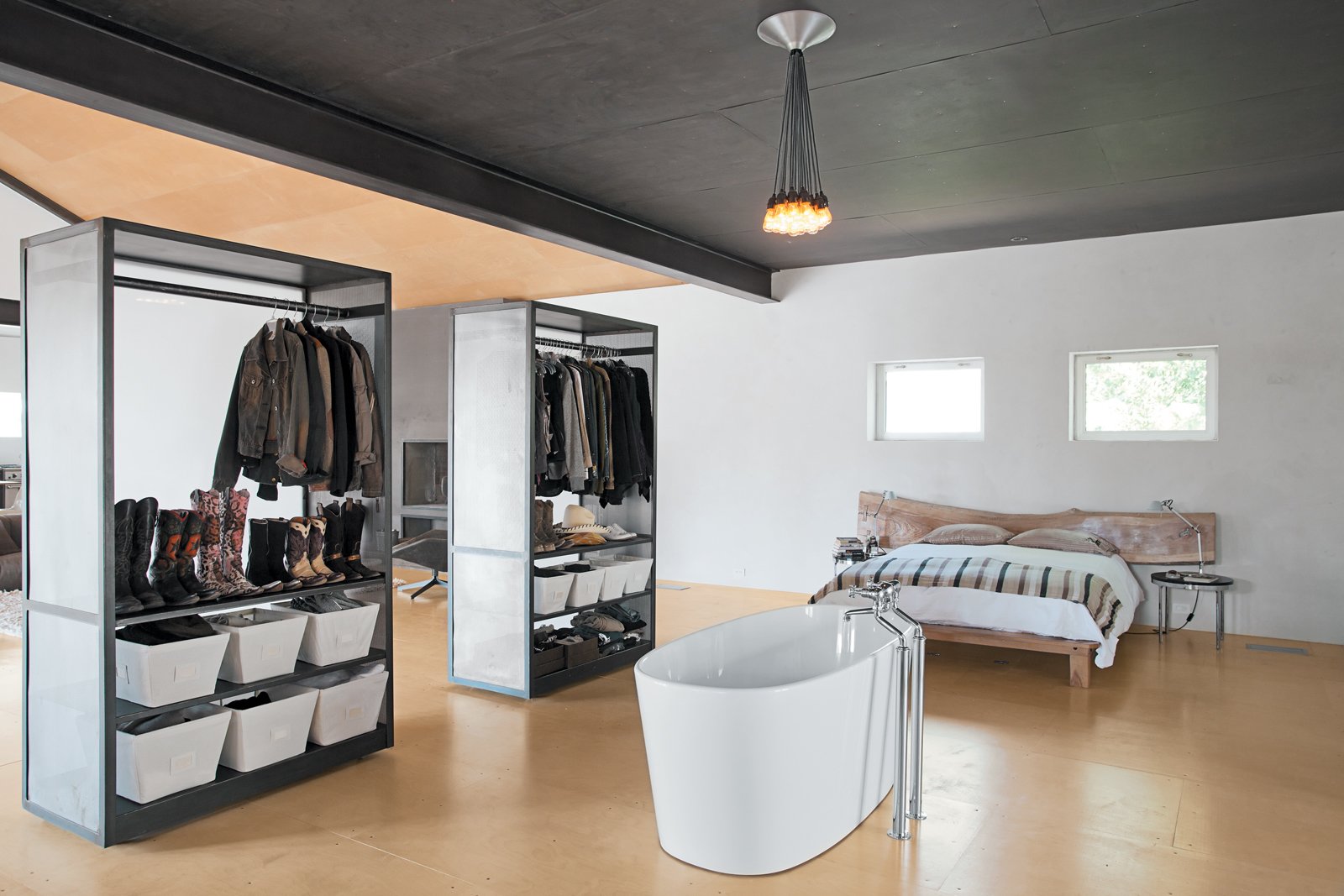 In the bedroom, an improbably placed tub is situated in front of two closets that can easily be maneuvered thanks to skateboard wheels affixed to the underside.