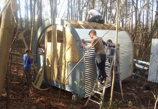 Volunteers for Mad Housers Inc. build an enclosure out of wood and corrugated metal. The Atlanta-based nonprofit build modest structures for homeless people with a goal of giving them a sense of security, privacy, and dignity. Photo courtesy of Mad Housers Inc.