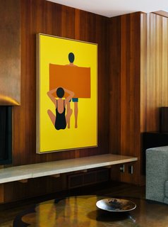 In the living room, the painting is by Geoff McFetridge and the wood paneling is original to the house. "Jewel-y color and simple shapes—they feel right in this house," says interior designer Jessica Helgerson.