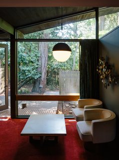 The couple designed the master bedroom, choosing a new red carpet inspired by the original and a Half Moon pendant by Allied Maker.