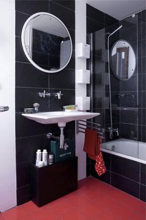 Green Living in Barcelona - Photo 14 of 14 - In the bathroom, recycled plastic tiles surround the tub. Designed by Ramón Benedito for Roca, the Kalahari sink was fashioned from a single piece of ceramic. "There’s less waste than the standard sink," says Scholtus, who also installed low-flow aerators in the faucets and a Stop Flush water-conserving toilet.<br><br>Don't miss a word of Dwell! Download our FREE app from iTunes, friend us on Facebook, or follow us on Twitter!