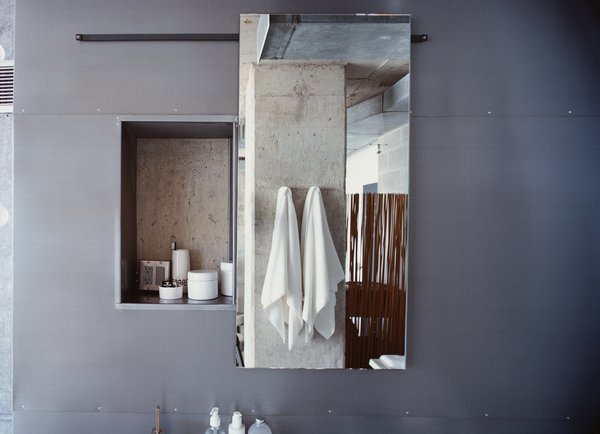 The door to Hill's medicine cabinet, made by George Sacaris, slides open to reveal a concrete wall.