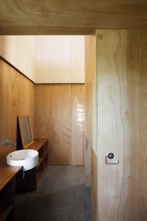 8 Inspiring Minimalist Bathrooms - Photo 7 of 7 - Minimalist doesn't have to mean monochromatic or marble. The Gaboon-plywood walls of the McKenzie residence in New Zealand flow through into the bathroom without a door to get in the way.