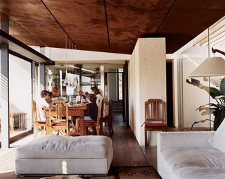 Though it’s inside, this light-filled room allows for a nearly alfresco dining experience. <br><br>The Fucsia pendant lamps are by Achille Castiglioni. The couch in the living area is by Antonio Citterio.