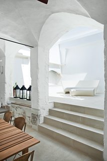 The indoor-outdoor Grand Plié sofa and Piaffé table, which the couple designed for Driade, perfectly suit the whitewashed courtyard, with curving silhouettes that echo the surrounding stonework. Serafini and Palomba purchased the metal lanterns at a local market.