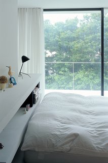 The bedroom has a view of the cherry trees.
