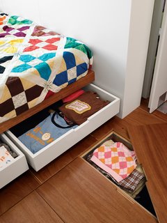 Storage under the bed and floor hides clutter in the master bedroom.