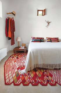 A Losanges rug by Ronan and Erwan Bouroullec, part of Nani Marquina's 2001 collection, anchors the master bedroom. The Basica Minima bedside lamp is from Santa & Cole, and the kilim pillows are by Philippe Xerri.