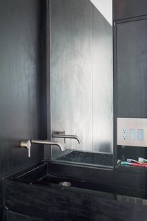 Atherton made the bathtub and sinks by hand, out of marine-grade plywood held together with aluminum spline joints and dyed with Behlen Solar Lux in jet black. To make them waterproof, he coated every surface in a thick layer of West System marine epoxy, popular with builders of wooden boats. The components are inexpensive, but the process is time consuming: Each piece took five days to make.