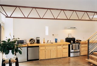The 40-foot-long countertop melds seamlessly with off-the-shelf kitchen cabinets and stainless steel appliances, creating an unbroken line along one side of the house.