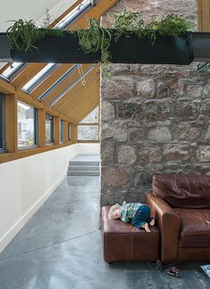 This Farmhouse is a Cor-Ten Steel-Clad Dream - Photo 7 of 11 - A Woolly Pocket planter hangs on the steel beam above a polished-concrete floor warmed by radiant heat.