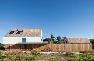 With its vertical wood slats, the garden fence helps unify the main house and the smaller shed.
