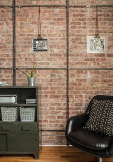 A Gut Renovation Transforms a Tiny Manhattan Apartment - Photo 3 of 8 - Abbes and Davison removed drywall to expose the brick on one wall in the living room. "As we began to expose that brick, we found the old metal framing that they used to use," Daivson says. "They used to stick chicken-mesh wire on it and put plaster on top. When we exposed the brick, we found this metal detail and decided to keep it." Photo by Alan Gastelum.