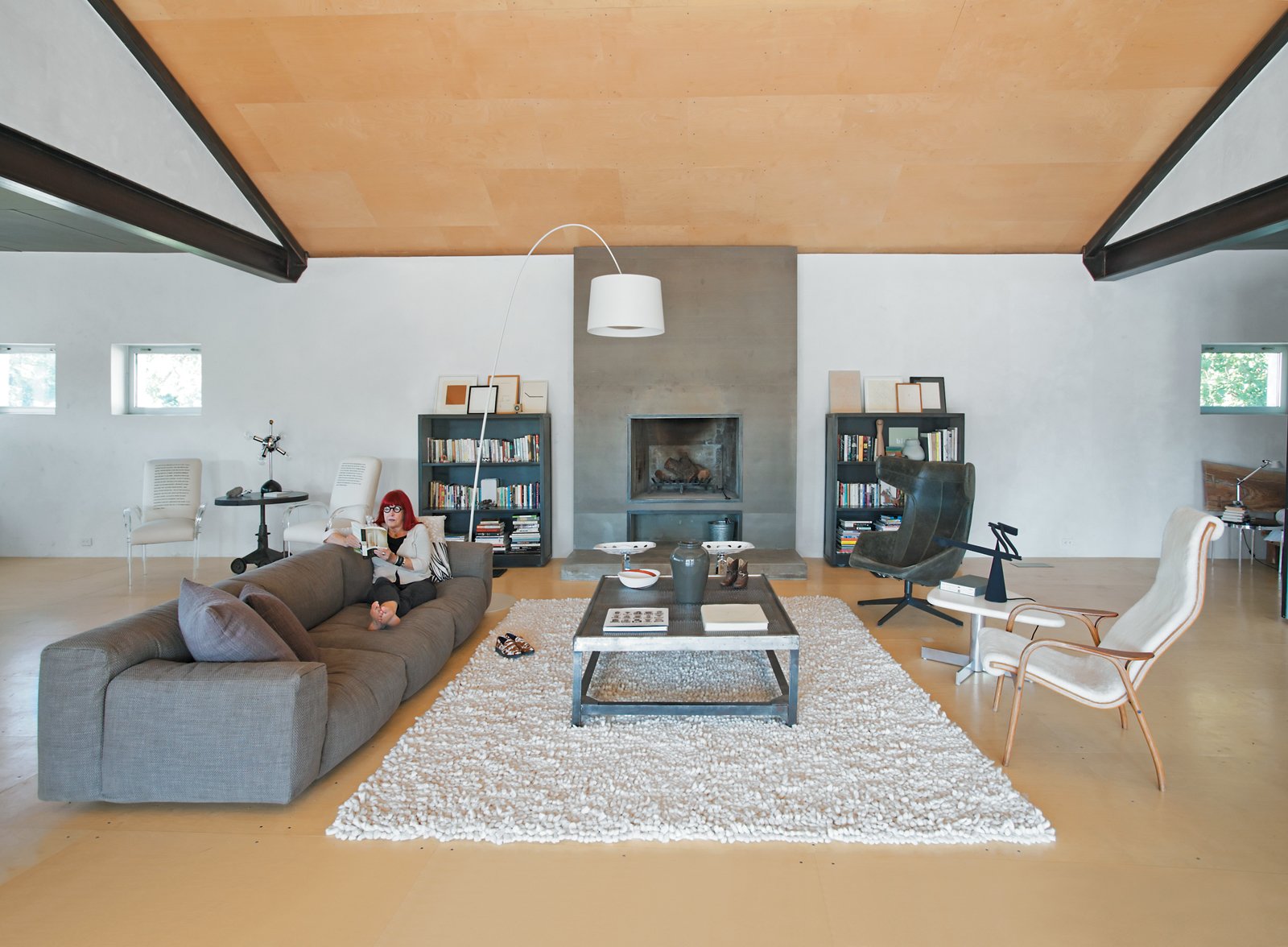 The seating area includes an extra-long sofa by Piero Lissoni, and a leather armchair designed by Alfredo H?berli for Moroso. The Twiggy lamp is from West Elm.