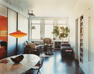 A ceiling-hung projection TV, aimed at a white wall, frees up floor space in the living room, where David Carmel’s modern pieces mix with Kirsten’s more traditional choices, including the wing chair and leather "fainting couch."