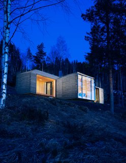 The cabin’s exterior walls and roof are clad in overlapping stone plates that mimic the look of traditional wood paneling found in Western Norway. "It provides an affinity with the cabins nearby," partner and architect Nils Ole Bae Brandtzæg explains. Solar panels cover the chimney pipe, lighting LED lamps inside.