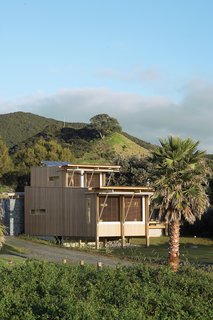 The cedar-clad home designed by Herbst Architects faces the Pacific Ocean, tucked behind sand dunes from the sparsely populated Medlands Beach.