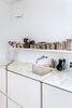 Molineus designed all of the storage units in the apartment, including the lacquered medium-density fiberboard cabinets under the kitchen sink, which is outfitted with a Vola faucet. Photo of How to Use Marble in the Kitchen modern home