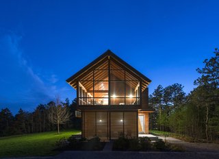 At night, the interior lighting casts the geometric window framing in silhouette.