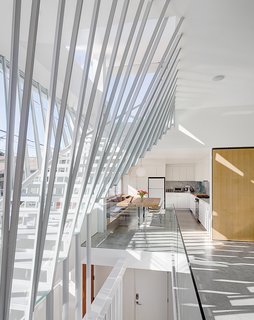 A Minimalist Duplex in Venice, California - Photo 2 of 9 - The dramatic staircase in architect Dom Dimster’s Southern California home is made from T- and L-profile steel, shelf board, glass panels, and plate steel. Electric shades on the outside of the house keep the sun from penetrating the glass wall of the staircase and overheating the interior. 