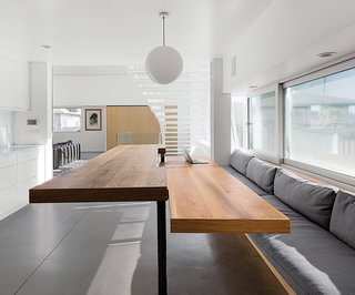 A Minimalist Duplex in Venice, California - Photo 6 of 9 - Half of the table can be manually raised to counter height, making an ideal serving, prep, or work station. "Don did all of the welding," Lisa says, "and I’d hold the fire-spark cloth to protect the cabinets and wood bench." Don originally wanted to have wood floors throughout the interior but for cost reasons decided to use lightweight concrete instead. "In order to make it as resilient to cracks as possible, the concrete is extra thick—two-and-a-half inches—and has fiberglass and wire mesh reinforcing," he says. "It was polished and machine-troweled as it was being finished, the same as the lower-level concrete slab, so we could get a similar look throughout."