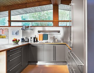 A Midcentury Home Keeps the History Alive - Photo 8 of 10 - A previous owner remodeled the kitchen in 2000, outfitting it with stainless-steel cabinets by Bulthaup as well as a Sub-Zero refrigerator and an induction stove by Diva.