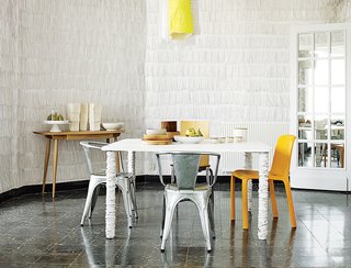 10 Modern Renovations to Homes in Spain - Photo 10 of 10 - Pedrali’s orange Frida 752 chair, two metal Tolix Marais chairs, and Philippe Starck’s Olly Tango seat surround a dining table that resident Pierre Pozzi wrapped in paper.