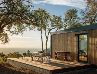 The deck offers views and a quiet spot for outdoor dining. The Western red cedar vertical siding is naturally resistant to rot and decay, making it a hardy choice for the exterior. The bronze wolf sculpture is by Sharon Loper.