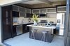 When it comes to decorating a small space, always remember to keep the scale of furniture in mind. “The biggest mistake I see people make when decorating a small space is small scaled furniture,” Berkus says. “You end up with a room that is scaled for a small space and is uncomfortable with nowhere to lounge around.” Berkus also suggests using software to test placement of furniture to help make more informed decisions about what works in every area of the home.
Pictured, a mid-century modern kitchen updated with black cabinetry and stainless steel appliances by contestant Andrew Flesher. Photo courtesy NBC. Photo of Renovation Tips from American Dream Builders' Nate Berkus modern home