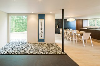 New McDonald - Photo 4 of 5 - Stone Roses<br><br>"We wanted to make the interior seamless with the outdoors, and this is the first place we blur the line," Katie says of the "stone garden" that flows from within the entry to the deck beyond it. "My 85-year-old father picked up the rocks at the beach, a bag or two at a time, over weeks and weeks," says Scott.