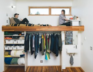 A pair of windows shed a bit of light in the bedroom, which boasts a lofted bed and workspace with a sink and closet beneath. The sink is by Lacava and the tap is from Fluid Faucet's Wisdom line.