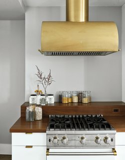 The Viking gas range is shown in Cotton White and finished in polished brass details to match the Workstead-designed hood.