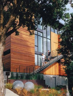 A Home with Eclectic Style Looks Just Right - Photo 3 of 19 - Baba and Bradley descend the staircase leading to the second-floor entrance, located above an in-law rental unit. The steel buoys are World War II era.