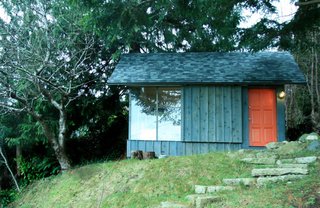 Tiny Studio Cabin by Hinterland Design - Photo 2 of 3 - A recycled barndoor track and wheels affords privacy behind a siding covered panel.