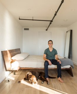 This Cozy Home Totally Changes How We Think of Tribeca Lofts - Photo 6 of 9 - The warm material palette extends to Berryman’s bedroom. Like the rest of the apartment, it features work by New York designers, including a custom wood bed by Asher Israelow and a Table Light desk lamp by Lindsey Adelman.