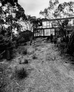 The rear facade is walled in glass and faces the sloping hillside.