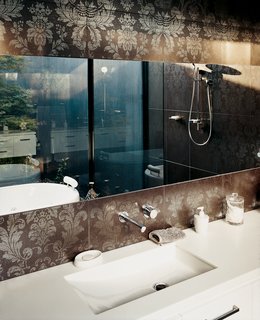Floral tiling on the walls of the master bathroom help ground that wing of the house, using earthly color and ornament to detail the space. As Aaron points out, it feels "more patterned, more personal down at this end of the house," and the bathroom, with its view of a Japanese maple, is one of the major reasons for this.