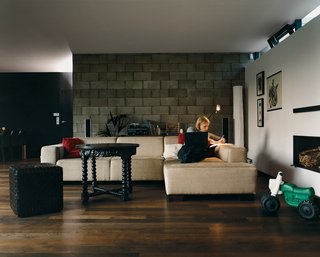 Johana works at home in the living room defined as much by its cinderblock wall as by the light coming in through recessed windows above. The house, while open, fluid, and defined by the circular outdoor space at its center, is also well partitioned, allowing both Johana and Tomáš to maintain private home offices.