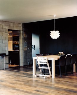 The dining space achieves its own clarity through a consistent color palette and strong angled lines. The white pendant light adds a sculptural detail.