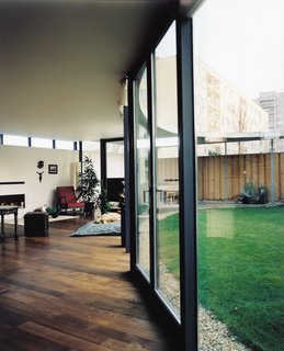 The EggO House’s inner glass wall is sealed like the windshield of a car, attached to <br><br>steel columns that also support the massive concrete roof. Outside, the lawn might be under the watchful gaze of the tower blocks across the street, but the concrete horizon of the roof affords a slight screen—and a psychological barrier—against prying eyes.