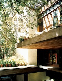 The front door is tucked under a cantilevered terrace.