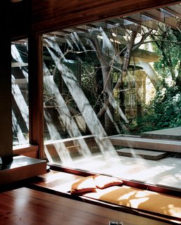 Wooden beams extend beyond the structure to create shading trellises for the terraces at the front and the back.