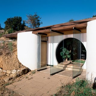 The glass doors of Muennig’s own home allow the ocean breeze through the circular entry of the sea-facing front.