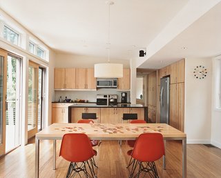 Shell chairs by Charles and Ray Eames surround a Portica table by Room & Board in the dining area. The bar stools are from Ikea.