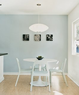 Due to the tight budget, the fixtures and furnishings had to be a mix of high and low. Instead of a Saarinen Tulip table for the dining room, they found a similar style with matching chairs from Ikea, then hung a George Nelson lamp overhead.